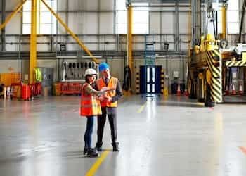 brokers review an industrial report in a warehouse